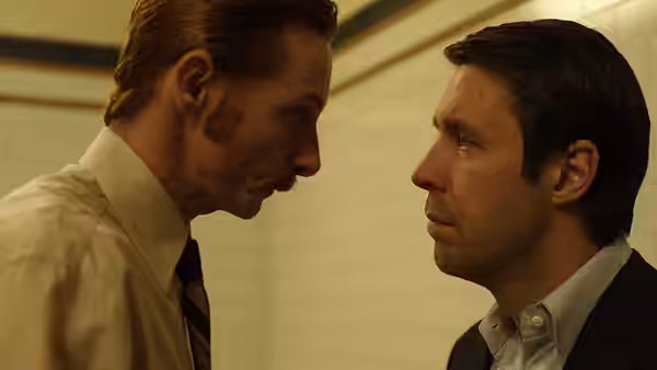 Two men facing each other closely in an intense confrontation indoors