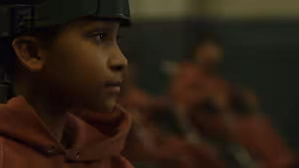 Melanie wears a helmet and looks toward someone offscreen