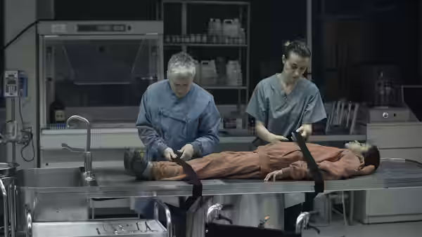 Dr. Caroline Caldwell and an assistant examine a restrained child in a laboratory