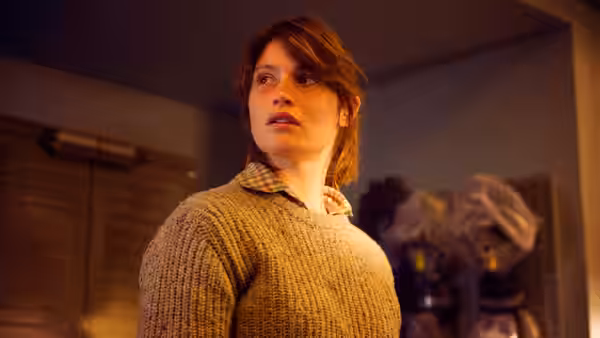 Helen Justineau turns toward something unseen inside a building