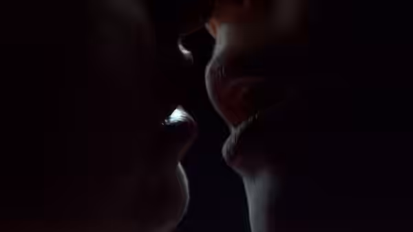 two women leaning in close with lips nearly touching
