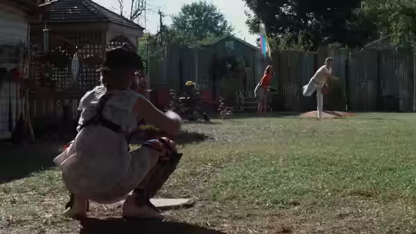 A catcher and pitcher playing baseball in a residential backyard