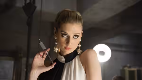 Victoria Vinciguerra (Elizabeth Debicki) holds a syringe in a dimly lit room