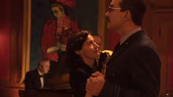 Jean Leslie (Kelly Macdonald) dances with a suited man at a party