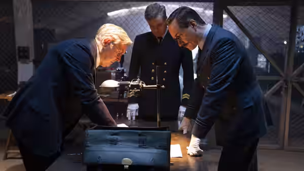 Three British officers examine an open suitcase in a secured laboratory