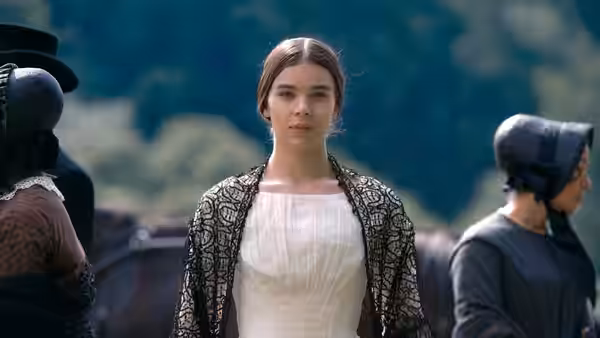 Young woman in white dress and lace shawl outdoors with others