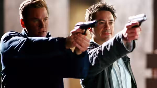 Gay Perry (Val Kilmer) and Harry Lockhart (Robert Downey Jr.) aiming handguns forward