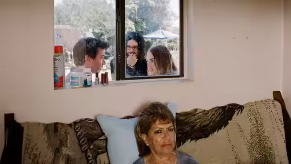 Elizabeth (Constance Shulman) on a couch watches people at a window