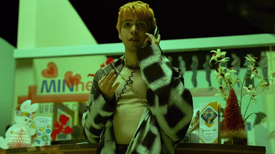 Julio Torres on the phone gesturing inside a convenience store