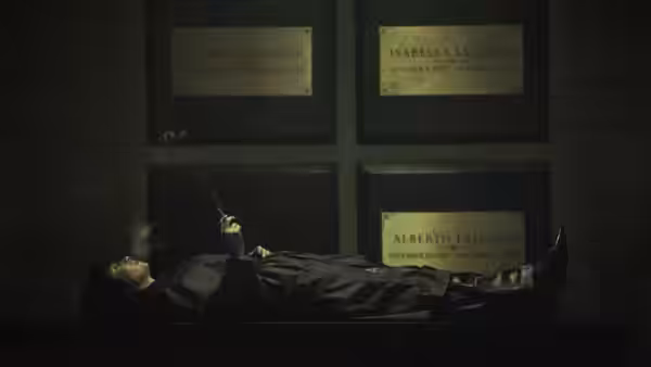Sofia Falcone lies on the floor smoking before family memorial plaques
