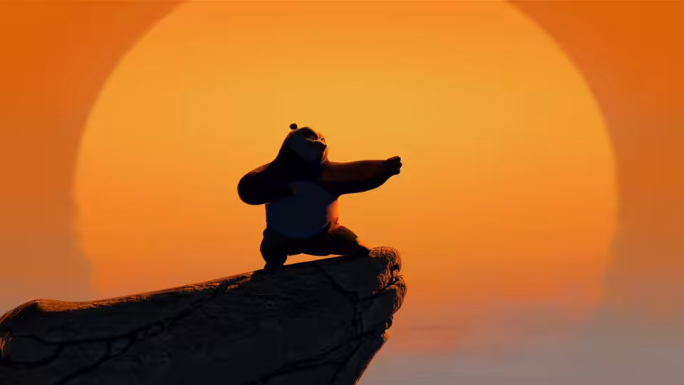 Po balances on a rocky outcrop, practicing a pose before the setting sun
