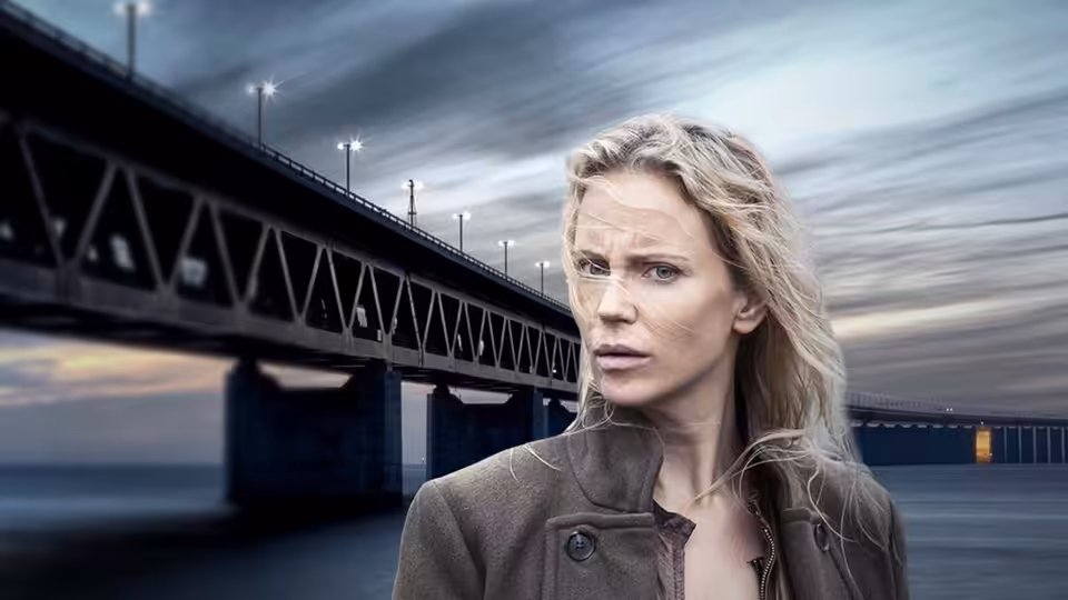 Saga Norén (Sofia Helin) stands before a large bridge over water with a serious expression