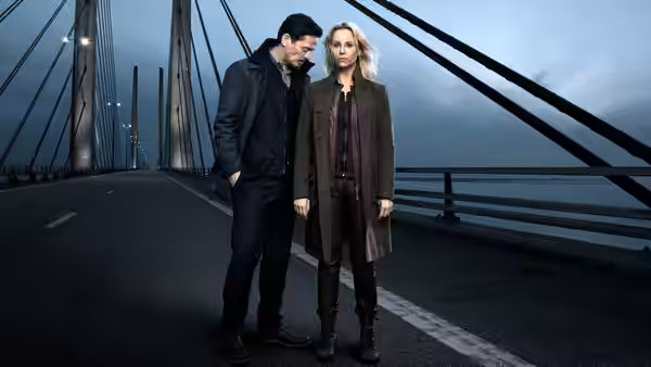 Saga Norén (Sofia Helin) and Henrik Sabroe (Thure Lindhardt) stand together on a bridge at dusk