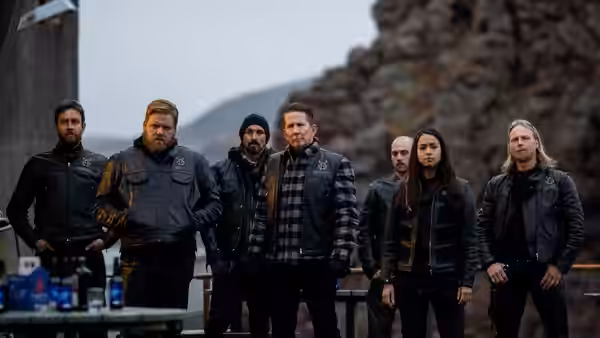 Andri (Ólafur Darri Ólafsson) stands with a group of people near rocks