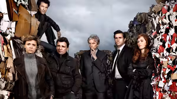 Six people stand among piles of shredded paper and debris