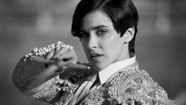 Carmen (Macarena García) raises a flower in her ornate bullfighter costume