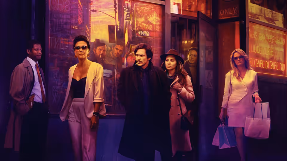 Group of men and women standing together on a sidewalk outside a building at night