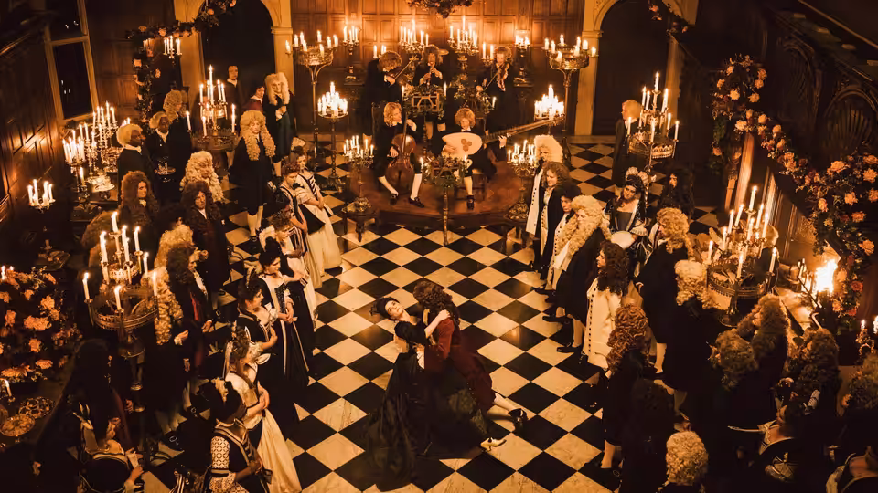 Courtiers in wigs and gowns gather on checkered floor beneath chandeliers