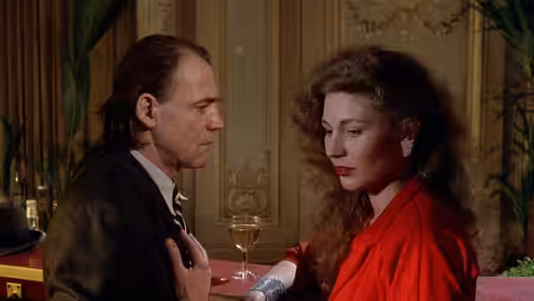 Peter Falk as the film star sits with a woman in a red dress
