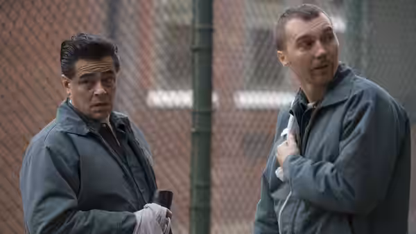 Richard Matt (Benicio del Toro) and David Sweat (Paul Dano) by a chain-link fence