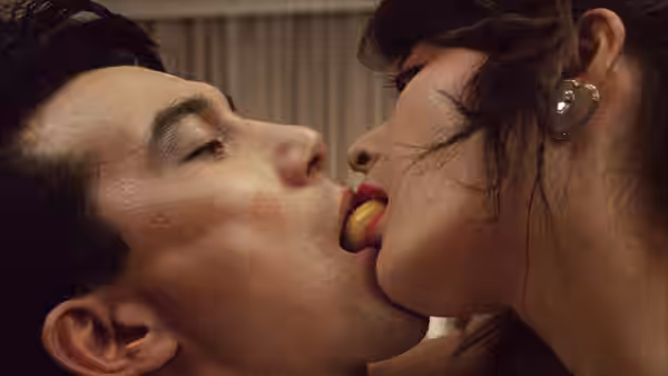 A man and woman share a morsel of food mouth to mouth