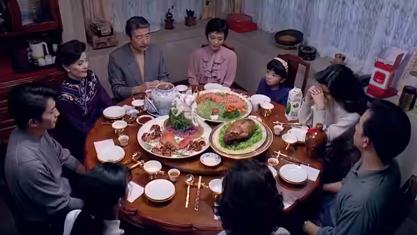 Mr. Chu and his family gather around a table laden with dishes