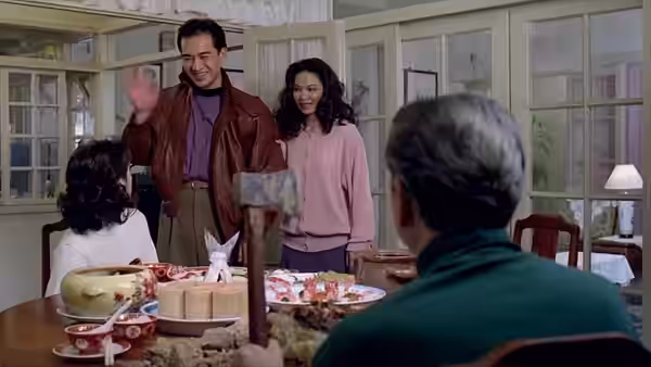 Li Kai and Jin-Rong greet Mr. Chu across a table of food