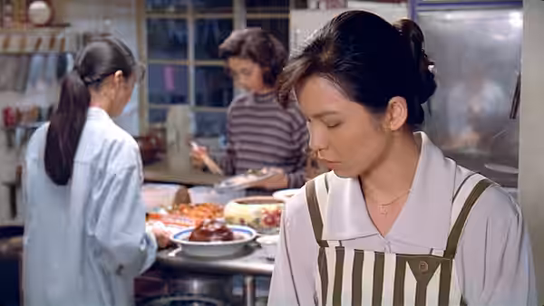 Jia-Ning stands in an apron beside a busy kitchen counter