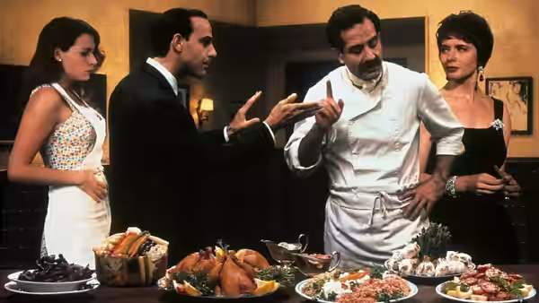 Secondo (Stanley Tucci) gesturing toward Primo (Tony Shalhoub) while Gabriella (Isabella Rossellini) and Phyllis (Minnie Driver) watch