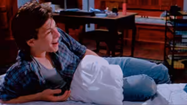 Jason J.D. Dean (Christian Slater) laughing on a bed