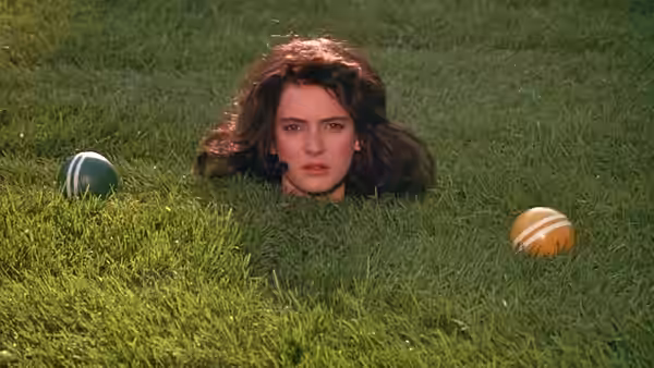 Veronica Sawyer (Winona Ryder) buried in grass with croquet balls
