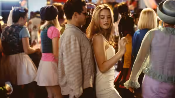 Cher (Alicia Silverstone) at a crowded party in a white dress
