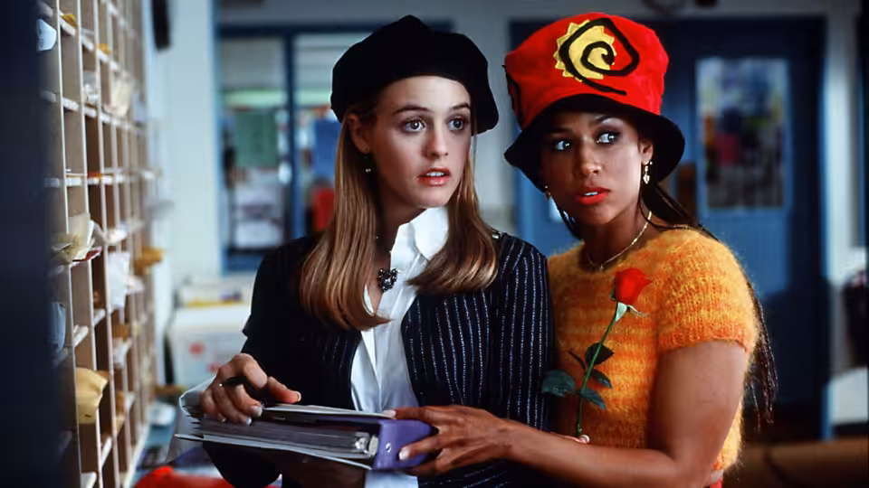 Cher (Alicia Silverstone) and Dionne (Stacey Dash) holding binders in an office