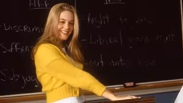Cher (Alicia Silverstone) pointing at notes on a classroom blackboard
