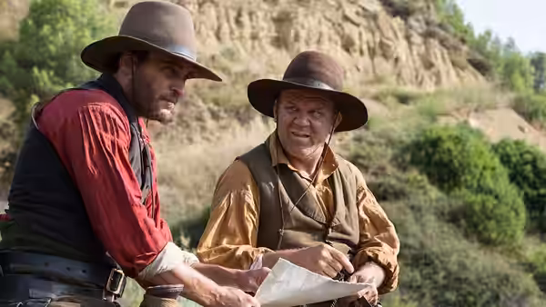 Charlie Sisters (Joaquin Phoenix) and Eli Sisters (John C. Reilly) study a map outdoors