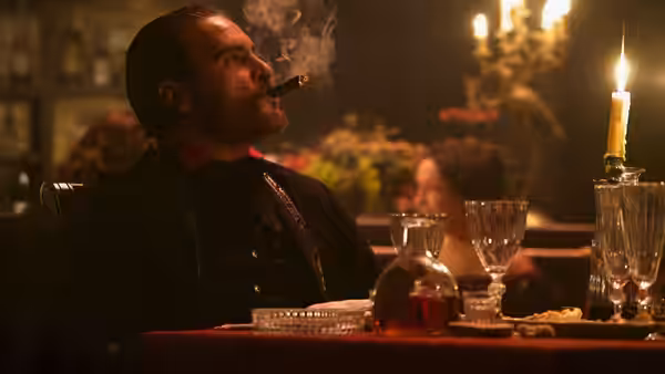 Charlie Sisters (Joaquin Phoenix) smokes at a candlelit saloon bar