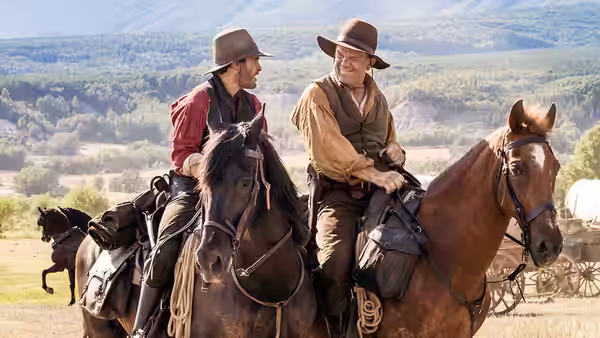 Charlie Sisters (Joaquin Phoenix) and Eli Sisters (John C. Reilly) ride horses across open country