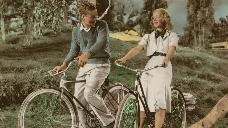 Laurel Dallas (Anne Shirley) and Richard Grosvenor (Tim Holt) ride bicycles together