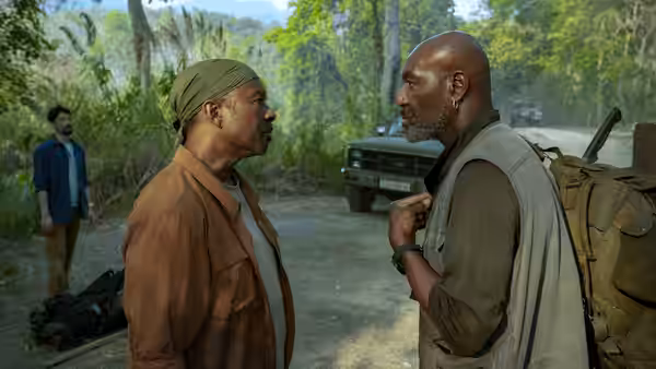 Paul (Delroy Lindo) faces Otis (Clarke Peters) beside a parked truck in the jungle