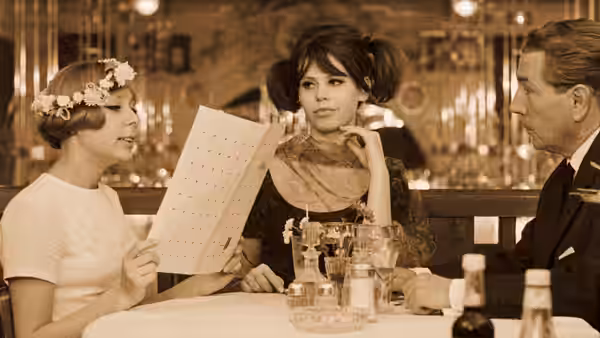 Two women and a man sit around a restaurant table with a menu