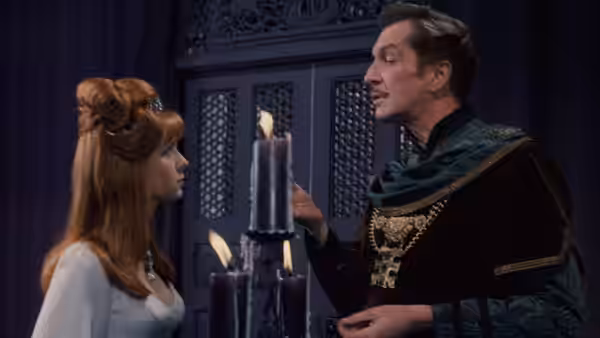Prince Prospero (Vincent Price) speaks with Francesca (Jane Asher) beside a cluster of candles