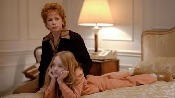 Gwen Verdon (Michelle Williams) stands behind a young girl lying on a bed
