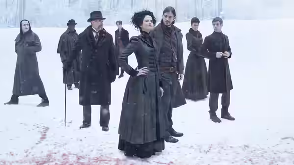 Vanessa Ives (Eva Green) stands in falling snow with companions nearby