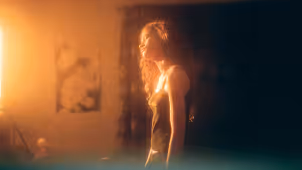 Rue Bennett (Zendaya) standing in a dimly lit room with sunlight