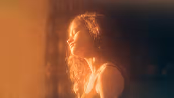 Rue Bennett (Zendaya) with eyes closed in warm light