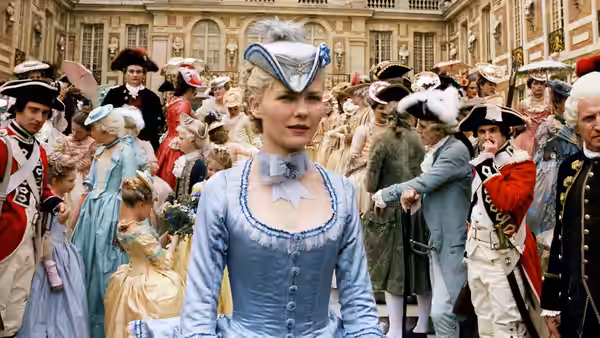 Marie Antoinette (Kirsten Dunst) walks through a crowded courtyard in a blue gown