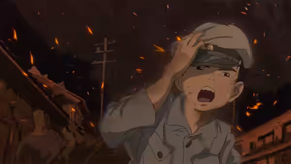 Mahito Maki shields his face amid embers in a burning street at night