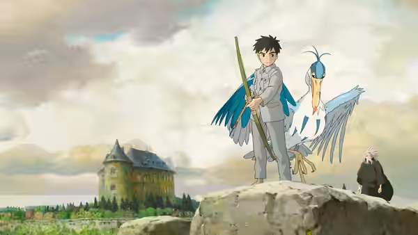 Mahito Maki stands with the Gray Heron on a rock near an old building