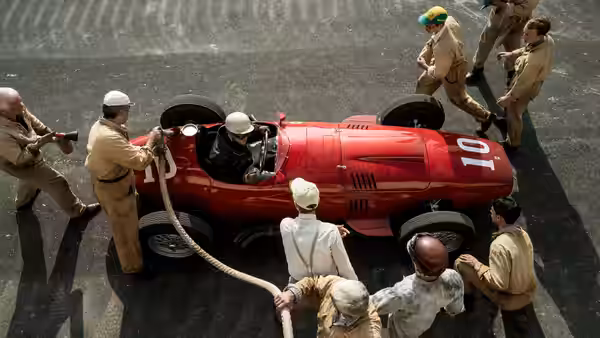 mechanics attending to a red racing car during a pit stop