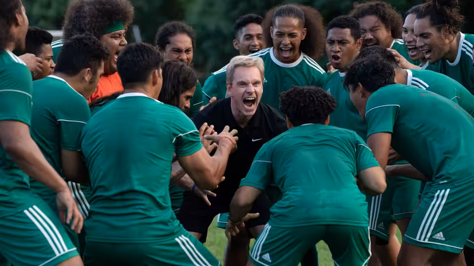 Thomas Rongen (Michael Fassbender) leading a team huddle on the field